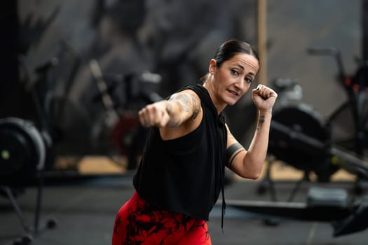 Frontal photo with focus on an expertise female fighter training in the gym