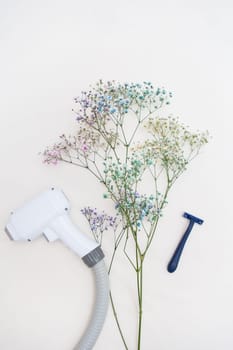 A laser hair removal machine and a razor are juxtaposed with delicate flowers on a light background, symbolizing the contrast between modern technology and the standard method of hair removal