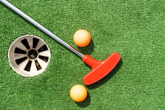 Golf stick and ball on green grass close up
