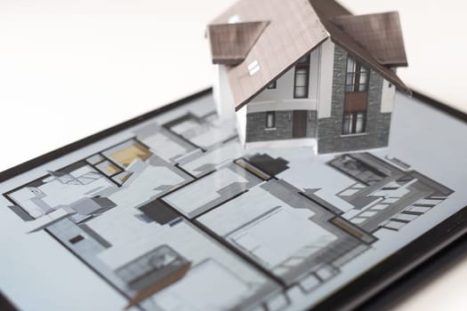 architecture, building, construction, real estate and home concept - close up of living house model on tablet pc computer screen