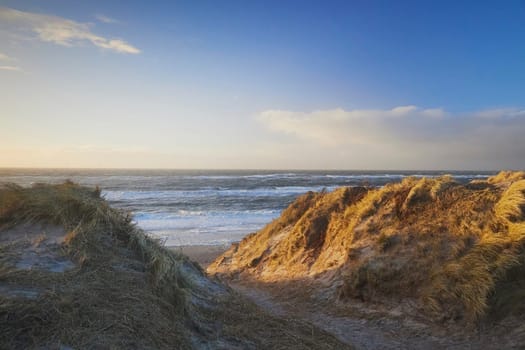 Stormy northern sea at sunset in Denmark. Coastal city Hvide Sande.