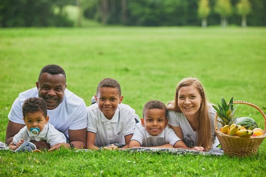 Tilst, Denmark, 12th of August, 2023: Interracial family on a picnic.