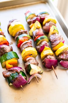 Flavorful beef and colorful veggie skewers, marinated and grilled to perfection, sizzling on a baking sheet.