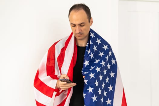 Young man holding an American flag on white background. High quality photo