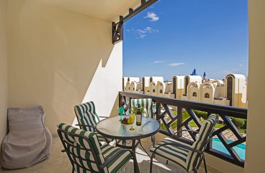 Terrace furniture of a luxury apartment in tropical resort with furniture and pool view from balcony