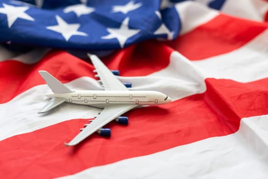 Travel in United States of America. Blank commercial airplane with four engines, on USA flag background, view from above. 3d illustration