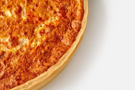 Closeup of browned quiche with crispy shortbread crust filled with savory custard, cheese and salmon, isolated on white background
