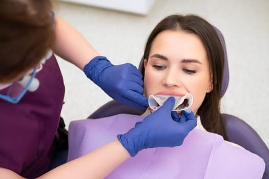 Orthodontist inserts a retractor into the mouth of the patient.