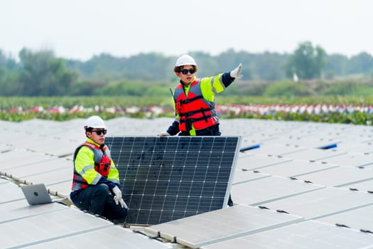 One technician worker sit and look to area that co-worker point to the right and discuss about work of solar cell panel in the network system.