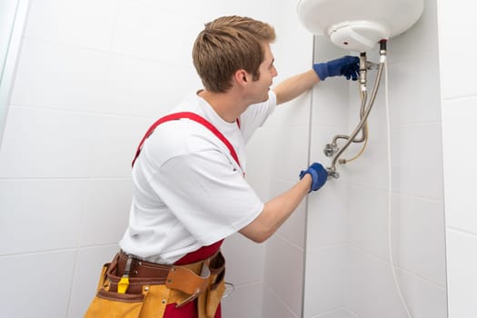 Professional plumber checking a boiler and pipes, boiler service concept