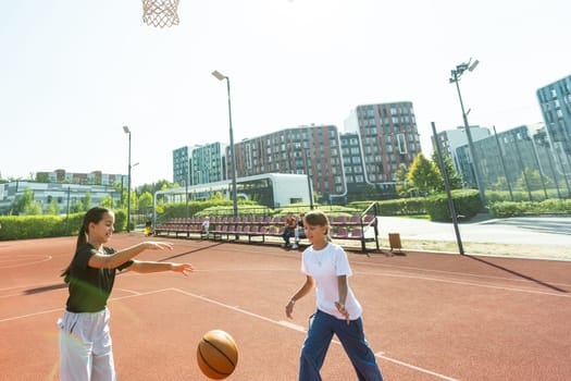 Teenager girl street basketball player with ball on outdoor city basketball court. High quality photo