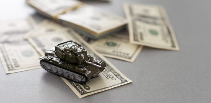 Tank on dollar bills. The concept of war costs, military spending. High quality photo