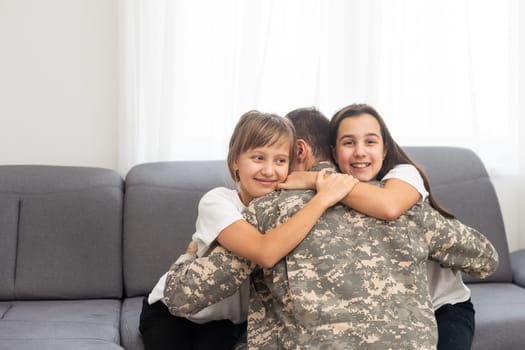 happy positive smiling soldier man in camouflage sitting with his daughter on sofa, looking how his kid grown when he was in army, returning home from war. High quality photo