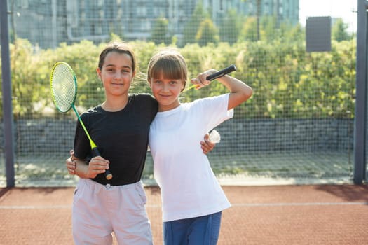 Two girls with badminton rackets on the football field. High quality photo