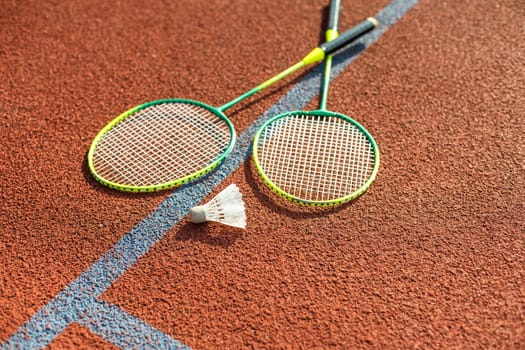 Badminton rackets and feather shuttlecock on the court. High quality photo