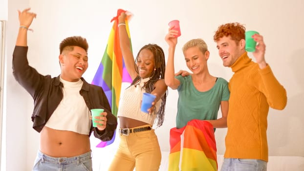 Multiethnic gay and lesbian friends partying with a lgbt flag at home