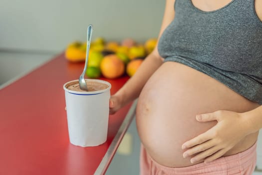 Happy pregnant young woman eating ice cream.