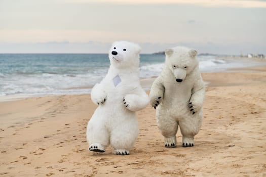 Animators dressed as polar bears entertain people on the beach. High quality photo