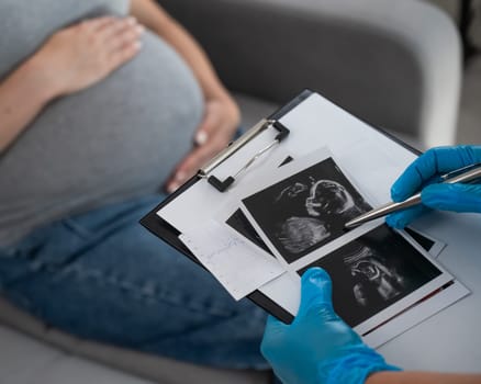 Gynecologist looks at an ultrasound of a pregnant woman