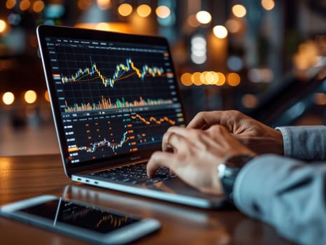 A man is deeply focused on analyzing a chart displayed on his laptop screen.