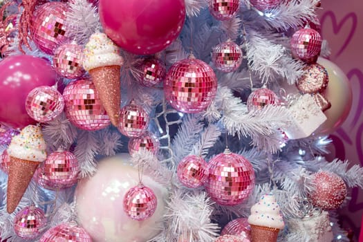 Closeup of Christmas tree decorated with pink shiny balls and icecreams. Christmas holiday concept. Beautiful white Christmas tree.
