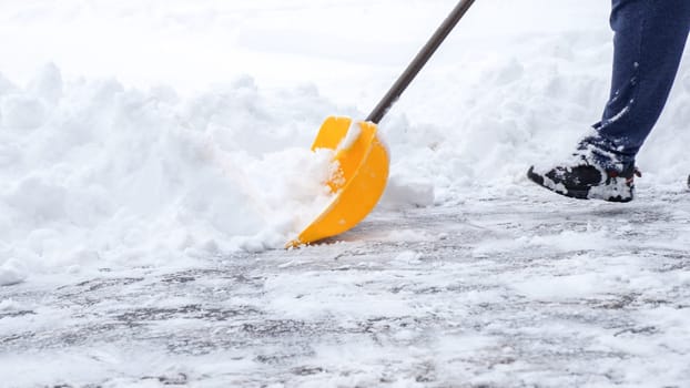 Man shoveling snow off of his driveway after a winter storm in Canada. Man with snow shovel cleans sidewalks in winter. Winter time