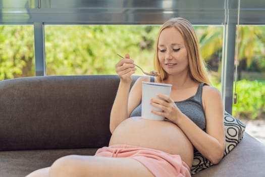 Happy pregnant young woman eating ice cream.