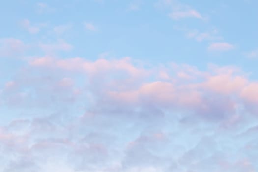 Background of blue sky with pale pink clouds in sunset