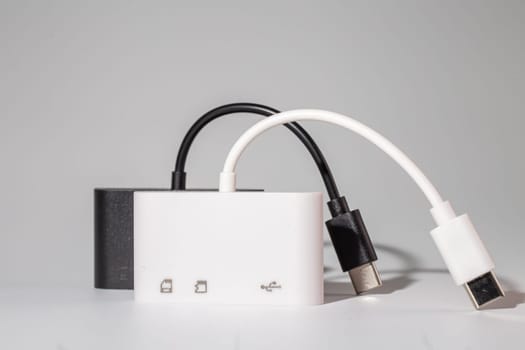 A sleek white and black charger for your electronic devices with two USB ports and a USB C cable. This handy gadget is a musthave for any communication device on the go