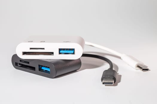 A sleek white and black charger for your electronic devices with two USB ports and a USB C cable. This handy gadget is a musthave for any communication device on the go