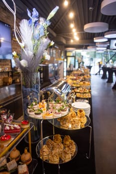 buffet table with a black tablecloth with various snacks and treats catering.