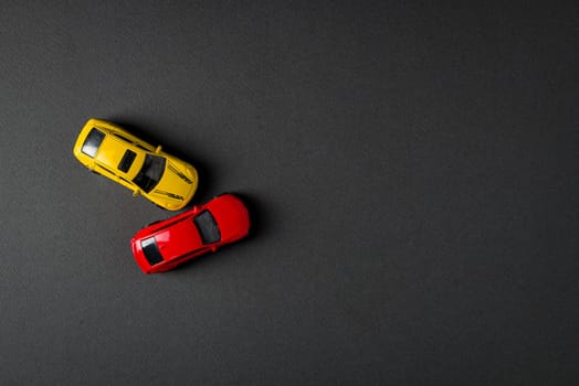 Top view of red and yellow cars colliding and crashing on dark gray background