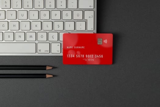 Top view of computer keyboard and credit card on dark gray table