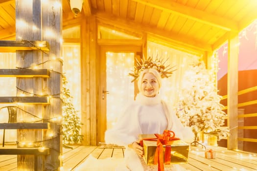 A woman in a white dress holding a gift box.