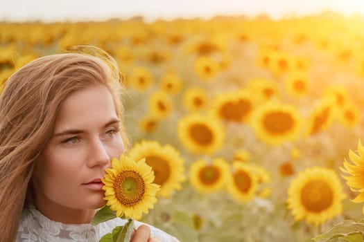 Woman in the sunflowers field. Summer time. Young beautiful woman standing in sunflower field.