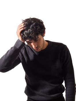 A middle-aged man wearing a black sweater is shown holding his head in a gesture of distress or frustration.