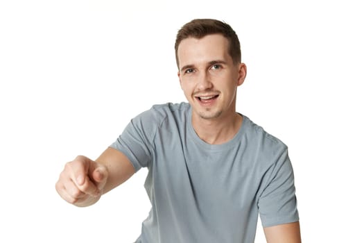 happy guy pointing at the camera on white studio background