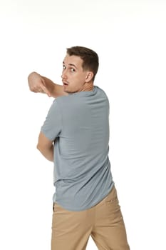 happy guy looking pointing to his back on white studio background