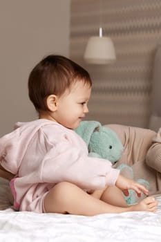 cute little child embracing toy bunny in bed