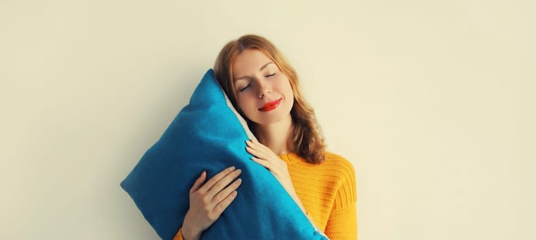 Healthy sleep, happy relaxed sleepy young woman hugs her soft comfortable pillow imagining that she is lying on the bed