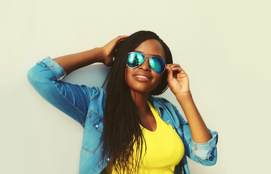 Portrait of stylish young african woman with dreadlocks posing wearing casual in the city