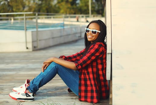 Portrait of stylish young african woman with dreadlocks posing wearing casual in the city