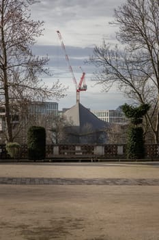 London, UK - Feb 15, 2024 - Construction work with crane and Hyperbolic-paraboloid roof of The design museum with sky background. Space for text, Selective focus.