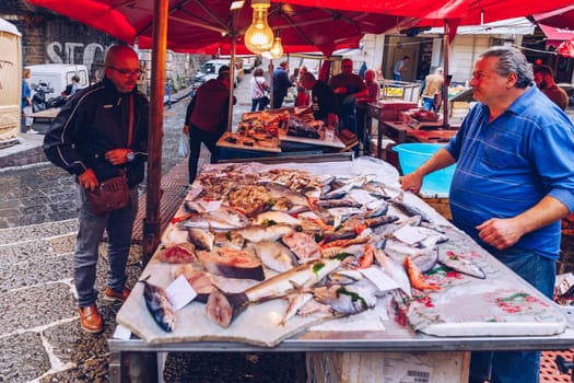 Catania, Italy - November 1, 2019: Seafood at fish market in Catania, Sicily, Italy. Fresh fish at the fish market in the old Town of Catania in the province of Sicily in Italy. 
