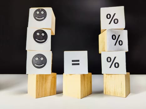 Wooden cubes in a column and row with white signs with a smiley sign, an arrow, a percentage. The concept of positivism. Positive thinking leads to the achievement of results and profits