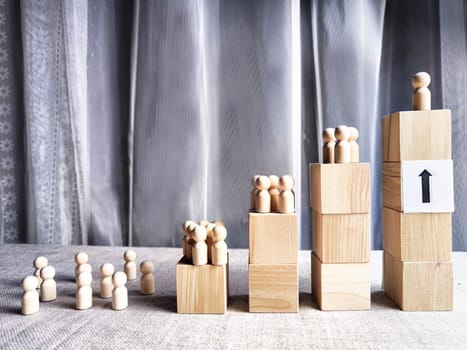 Wooden toy doll on high pedestal and many other figures below. Concept of leadership, which is not available to everyone. Victory and the winner. Talent, Recruitment employee and Successful business