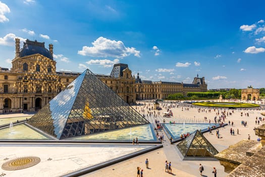 Paris, France - July 6, 2018: View of the Louvre Museum, the world's largest art museum and a historic monument in Paris, France, on a sunny day. Panoramic view of Louvre Museum and it's courtyard.