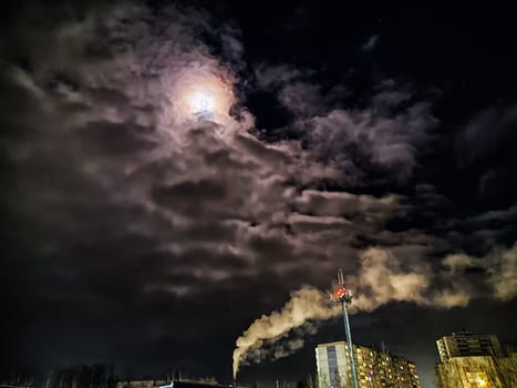 Winter night industrial landscape. Coal-fired power station with smoking chimneys against dramatic dark sky. Carbon dioxide CO2 emissions as primary driver of global climate change. Air pollution
