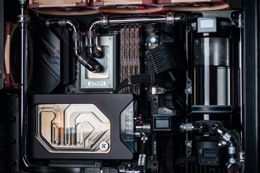Prague, Czech Republic - 21 July 2021: Close-up of high performance Desktop PC and water cooling system with multicolored LED RGB light show status on working, interior on Computer PC Case and DIY
