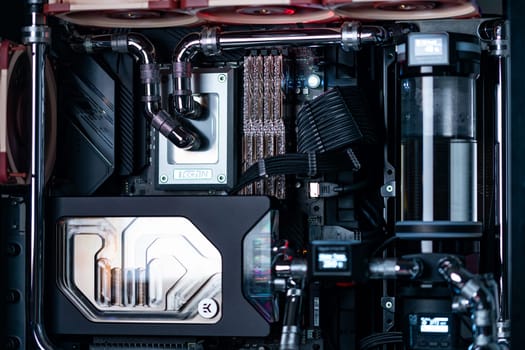 Prague, Czech Republic - 21 July 2021: Close-up of high performance Desktop PC and water cooling system with multicolored LED RGB light show status on working, interior on Computer PC Case and DIY